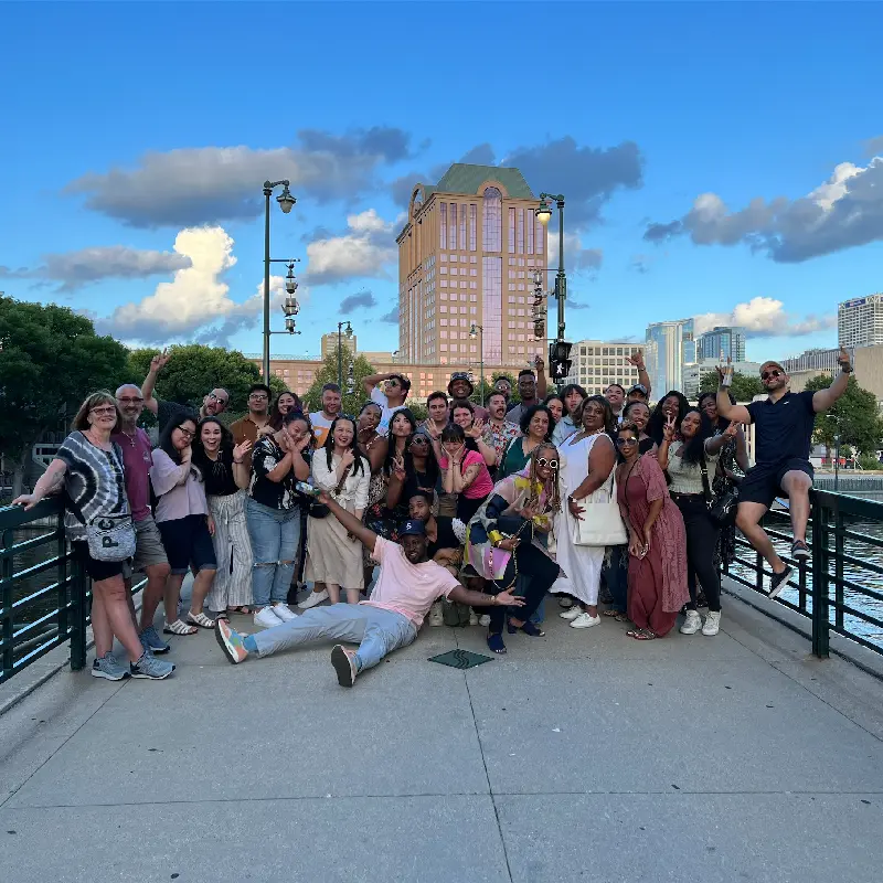 A group of CMRignite team members in front of the Milwaukee skyline.
